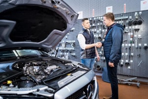 Fahrzeugübergabe vor dem Mercedes-Service in der Werkstatt.